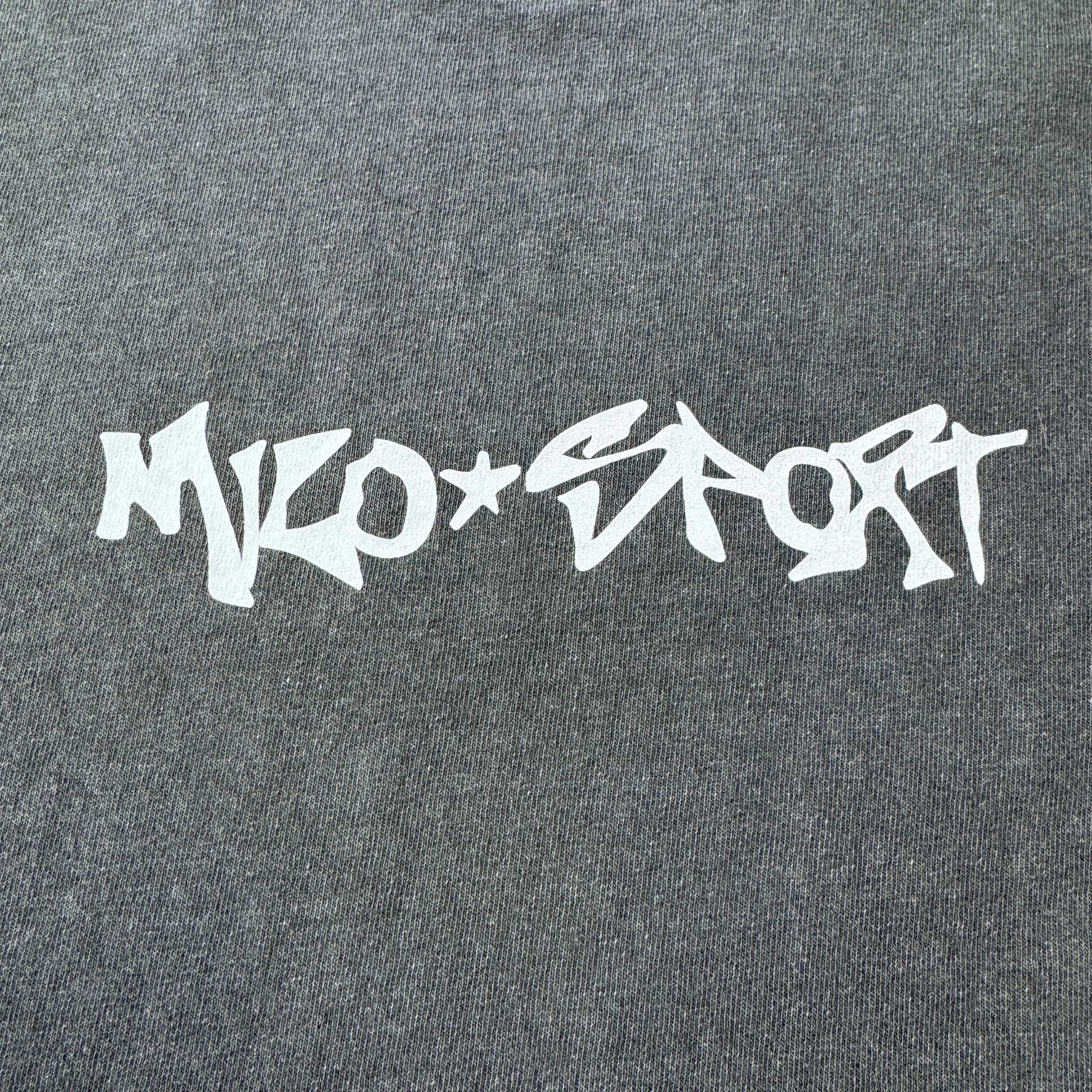 Mens Milosport Heavyweight Spray T-Shirt displayed on a hanger, featuring a casual fit and graphic design.